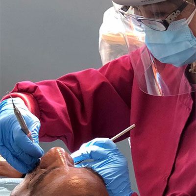 Joseph Abe, DDS dental assistant working on a patient